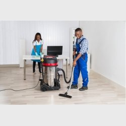 Femme et homme de menage nettoyant un bureau